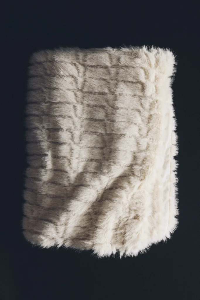 Copriletto H&M Home color crema con superficie pelosa e motivo a quadri.