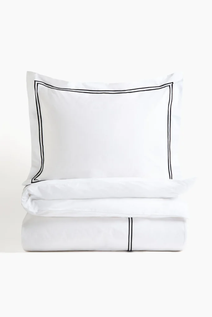 Copripiumino e federa H&M Home bianchi con doppio bordo nero.
