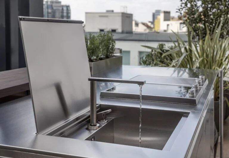 Dettaglio del lavello di Solaria con copertura sollevata, rubinetto e moduli cottura sul terrazzo