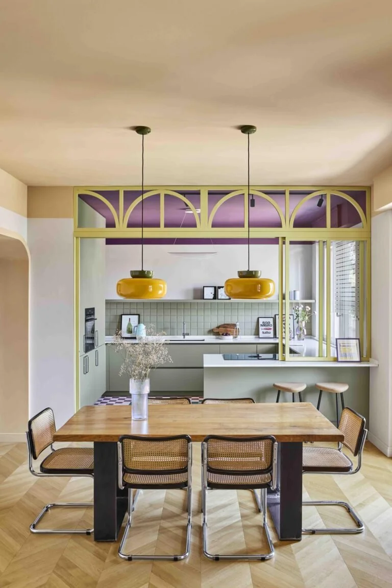 Zona pranzo di Residenza B05 con soffitto pesca e cucina verde