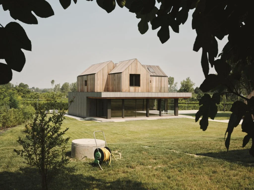 Treehouse vista dal verde con i volumi in legno sopra il basamento