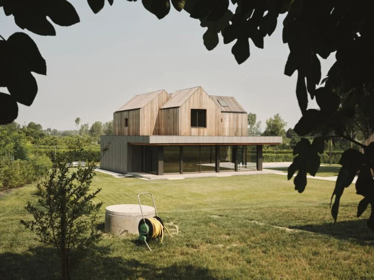 Treehouse vista dal verde con i volumi in legno sopra il basamento