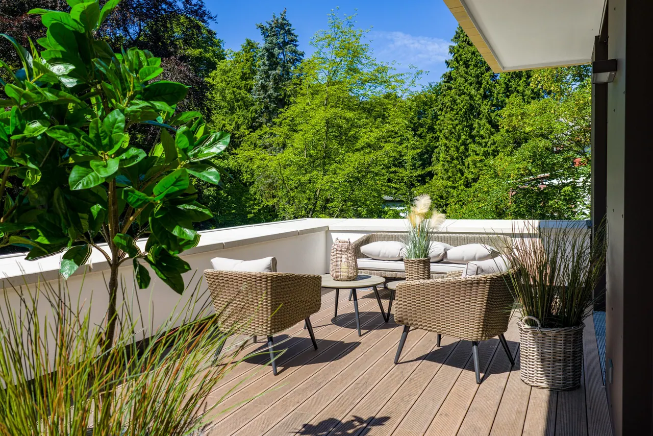 Terrazzo con sedute intrecciate e piante affacciato sul verde