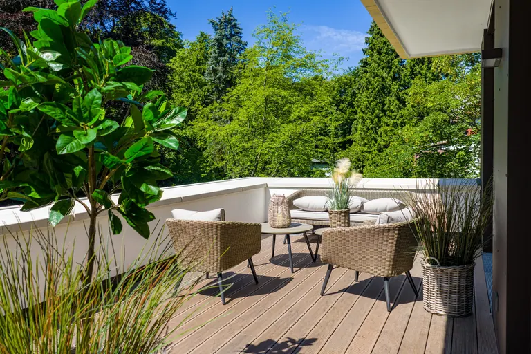Terrazzo con sedute intrecciate e piante affacciato sul verde